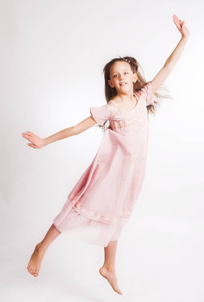 little girl jump over white background - Foto, afbeelding