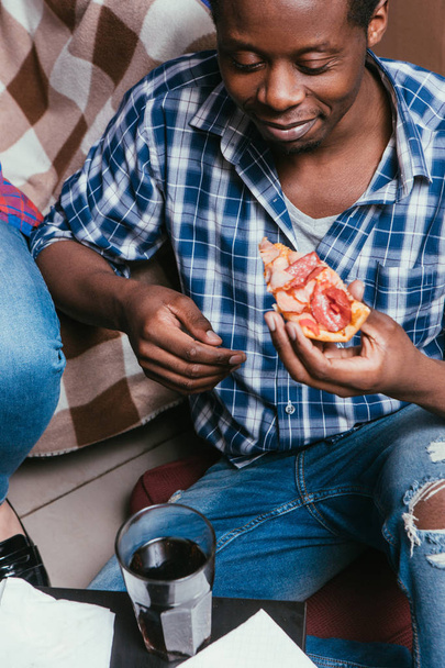 Black man eat pizza with soda at home, closeup - Fotó, kép