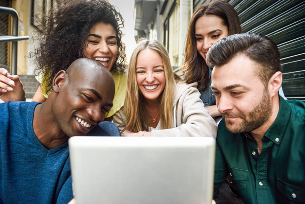 Багатоетнічна група молодих людей дивиться на планшетний комп'ютер
 - Фото, зображення