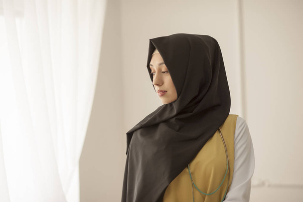 Portrait of a modest Muslim woman on a light background - Фото, изображение