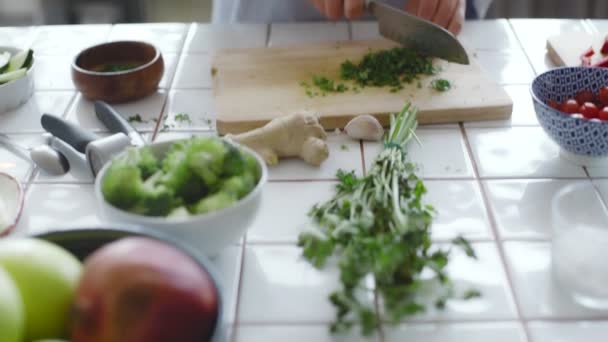Hands chopping vegetables on wooden cutting board - Filmagem, Vídeo