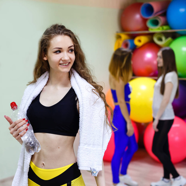 Young girl with a towel holding a bottle of water while training - Foto, Imagem