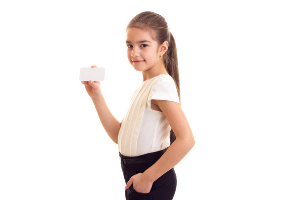 Little girl in white T-shirt holding white card - Фото, изображение