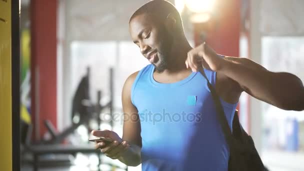Successful young male chatting in smartphone app after workout, flirting online - Imágenes, Vídeo