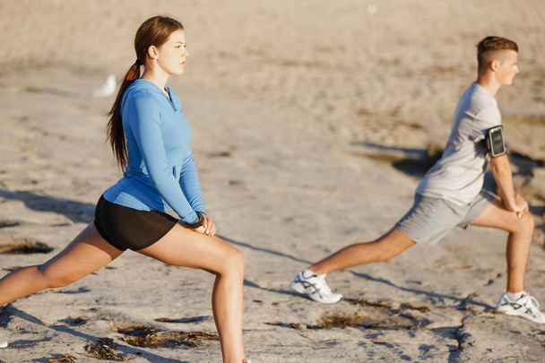 Jeune couple sur la plage d'entraînement ensemble
 - Photo, image