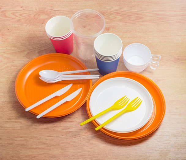 Different plastic and paper disposable cutlery on a wooden surface - Photo, Image