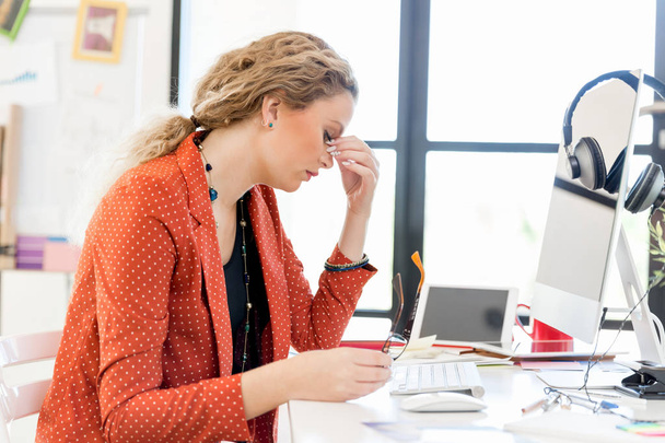 Young woman in office tired - Foto, Bild