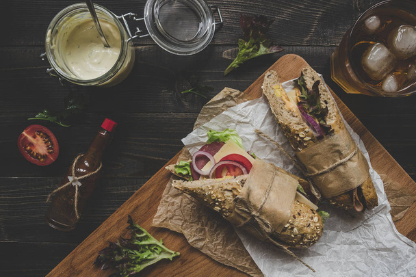 Fresh delicious submarine sandwiches on the wooden table. Top vi - Φωτογραφία, εικόνα