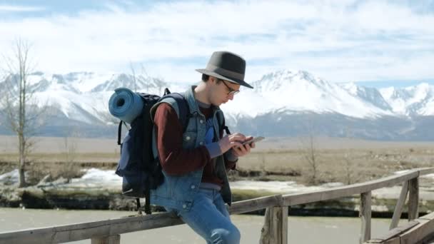Young Man Traveler with backpack, Viewing map in digital mobile phone relaxing outdoor on background. 20s 4k - 映像、動画