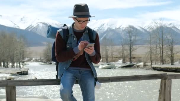 Young Man Traveler with backpack, Viewing map in digital mobile phone relaxing outdoor on background.20s 4k - Footage, Video