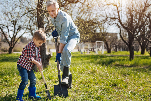 gardener and  grandson digging ground together - Φωτογραφία, εικόνα