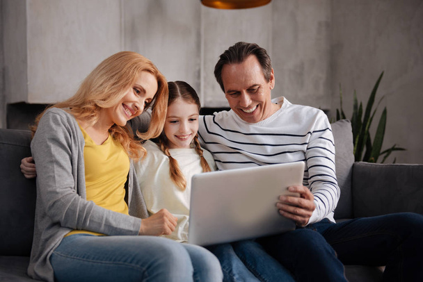 Positive family using electronic gadget at home - Fotó, kép