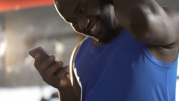 Shy handsome man reading message on smartphone with smile on face, flirting - Filmagem, Vídeo