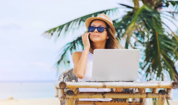 Young woman working in laptop on the beach. Freelance work - Фото, зображення