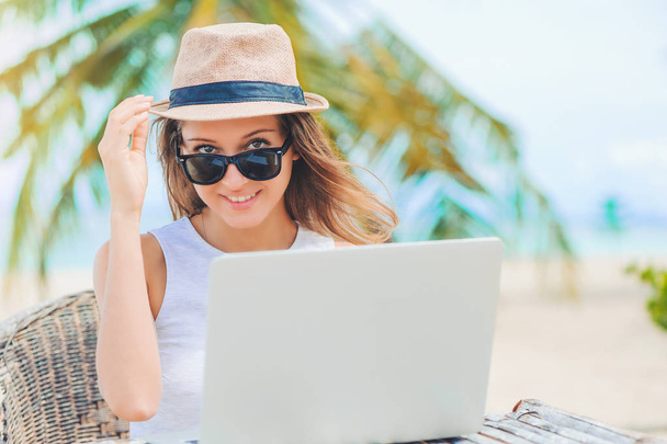 Young woman working in laptop on the beach. Freelance work - Φωτογραφία, εικόνα