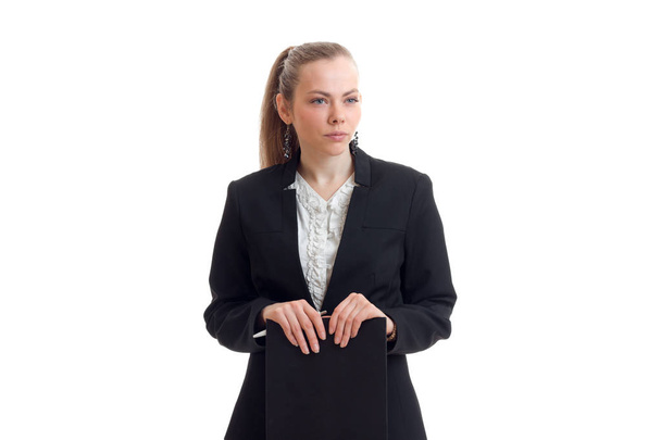 молодая очаровательная девушка в черной куртке выглядит прямо и держит планшет
 - Фото, изображение