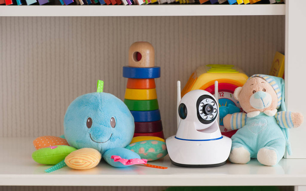 Telecamera IP sullo scaffale con giocattoli, che funge da baby monitor - Foto, immagini