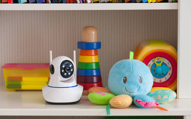 Caméra IP sur l'étagère avec des jouets, servant de moniteur de bébé - Photo, image