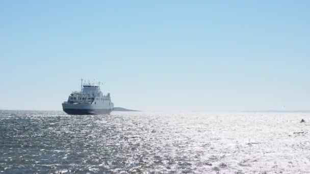 Pequeño ferry que cruza sobre el agua reluciente en el viento vendaval
 - Metraje, vídeo