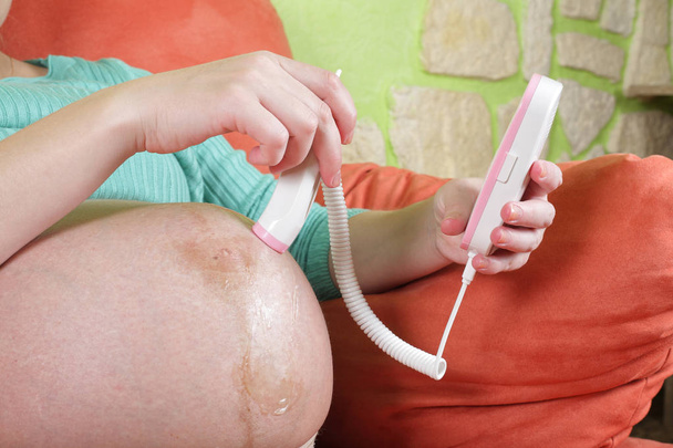 Беременная женщина с фетальным доплером
 - Фото, изображение