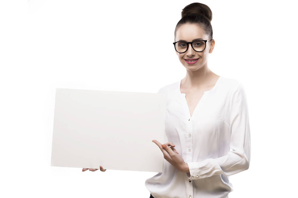 office girl holds in hands blank white plate on a white backgrou - Фото, изображение