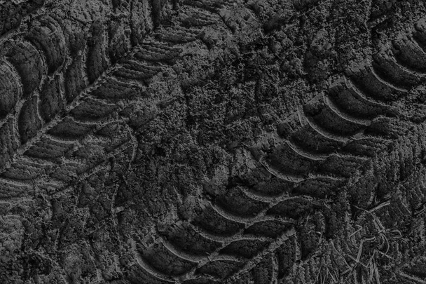 Печать следов шин в грязной грязи с черным песком
 - Фото, изображение