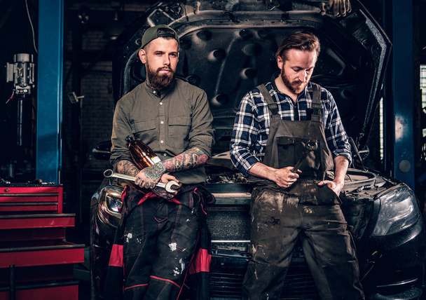 Deux mécaniciens tatoués barbus
 - Photo, image