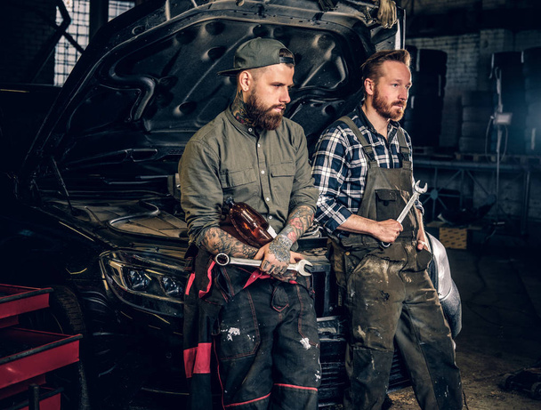 zwei bärtige tätowierte Mechaniker - Foto, Bild