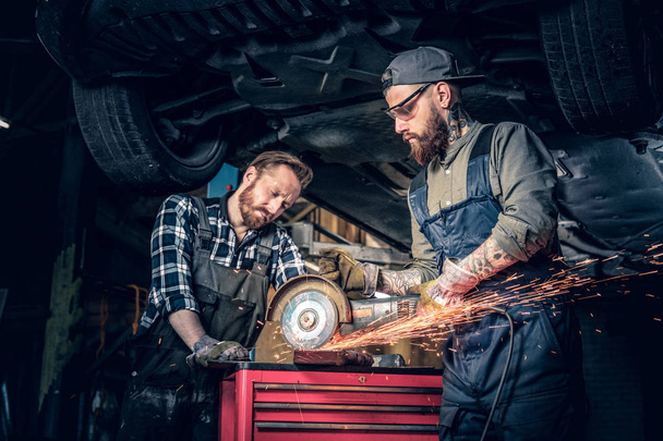 Mechaniker arbeiten mit einem Winkelschleifer - Foto, Bild