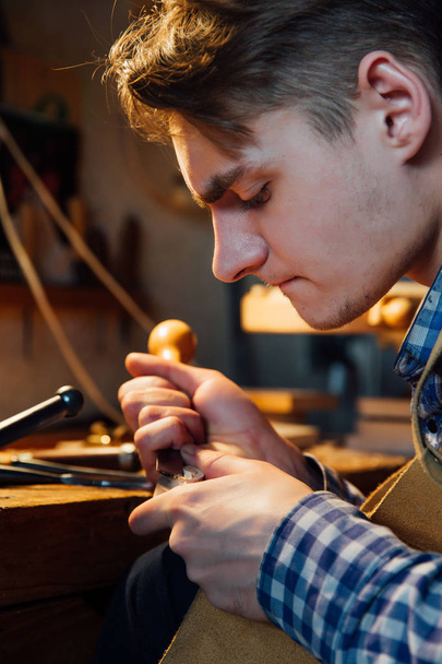 Master artisan luthier working on the creation of a violin. painstaking detailed work on wood. - 写真・画像