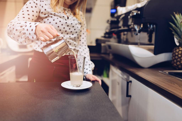 Café empregado barista derramando leite quente espumado para vidro
 - Foto, Imagem