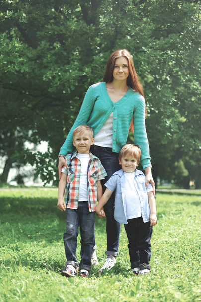 Happy family together! Mother and two children sons walking in t - Photo, image