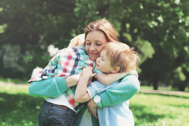 Happy smiling mother is embracing children at summer day - Fotografie, Obrázek