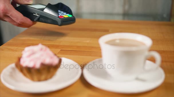 Una mujer paga un desayuno dulce con un pago de tarjeta de plástico sin contacto
 - Metraje, vídeo