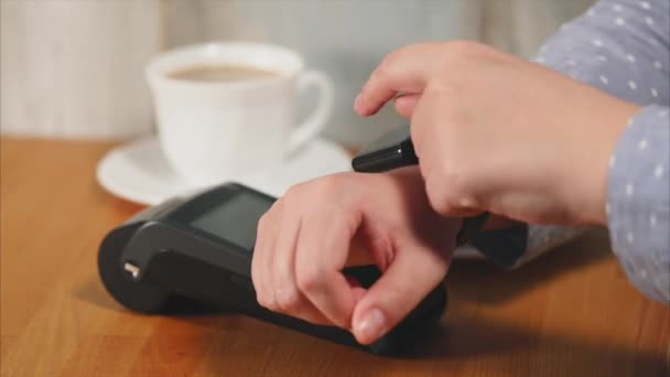 Persoon handen betalen contactlessly koffie en cake met slimme horloge met terminal - Video