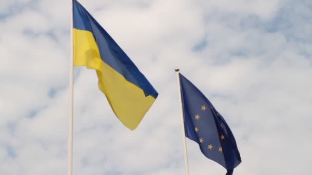 Vlajka Ukrajiny a vlajka Evropské unie vlající na pozadí zamračená obloha. - Záběry, video