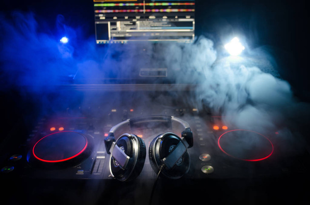 DJ Spinning, Mixing, and Scratching in a Night Club, Hands of dj tweak vari controlli delle tracce sul ponte del DJ, luci stroboscopiche e nebbia, messa a fuoco selettiva, da vicino. Concetto di vita del Dj Music club
 - Foto, immagini