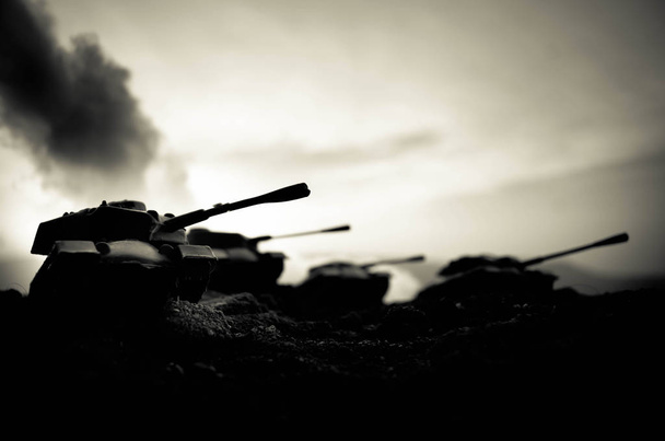Sota-ajatus. Sotilaallinen siluetit taistelevat kohtaus sodan sumu taivaalla tausta, maailmansodan sotilaat siluetit alla pilvinen Skyline yöllä. Hyökkäyskohtaus. Panssaroituja ajoneuvoja. Säiliöt taistelu
 - Valokuva, kuva