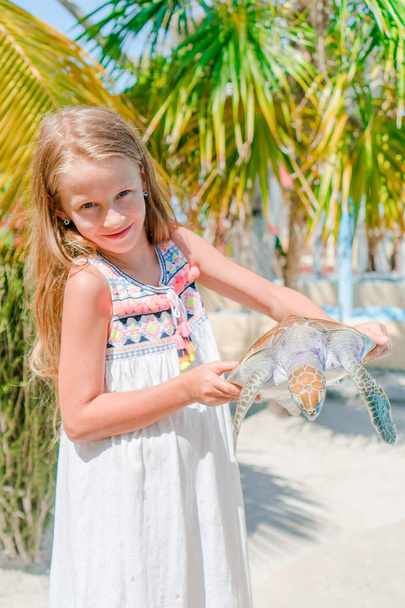 Urocze dziewczynki z małego żółwia w jej ręce w rezerwie - Zdjęcie, obraz