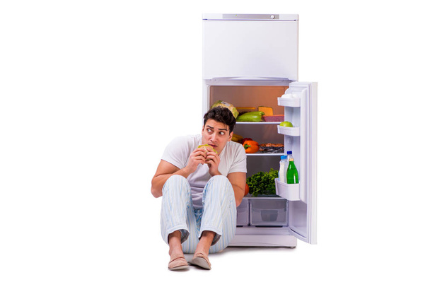 Homem ao lado do frigorífico cheio de comida
 - Foto, Imagem