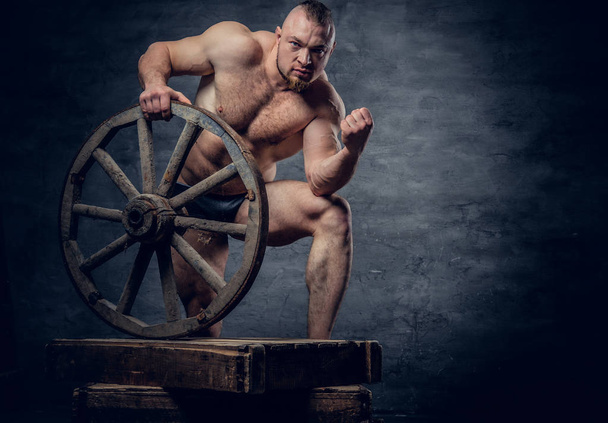 Man posing with old wooden wheel  - Photo, Image