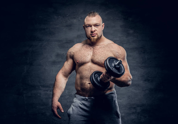 Athletic man posing with dumbbell  - Photo, image