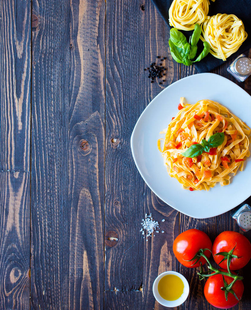 Tagliatelle with tomato and basil, made at home, on a wooden bac - Photo, Image