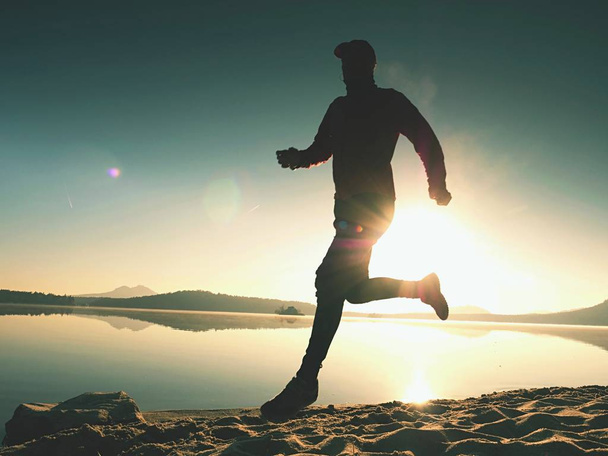 日の出海岸で実行されているアクティブなアスリート ランナーのシルエット。朝の健康運動 - 写真・画像