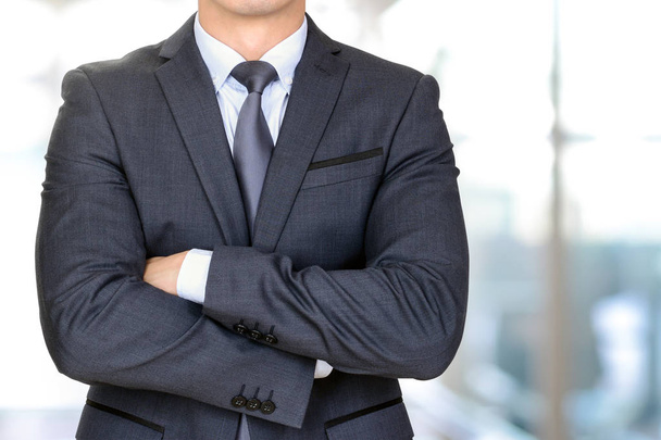 Homem de negócios anônimo em terno cinza escuro cruzando seus braços
 - Foto, Imagem