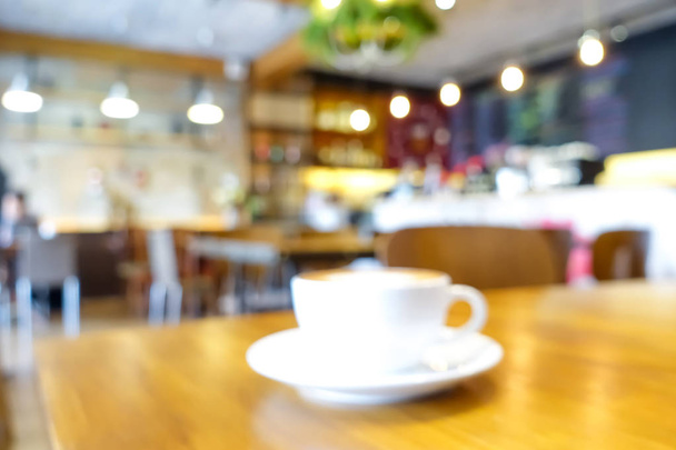 Rozmycie wnętrza kawiarni z filiżanką kawy na stole - Zdjęcie, obraz