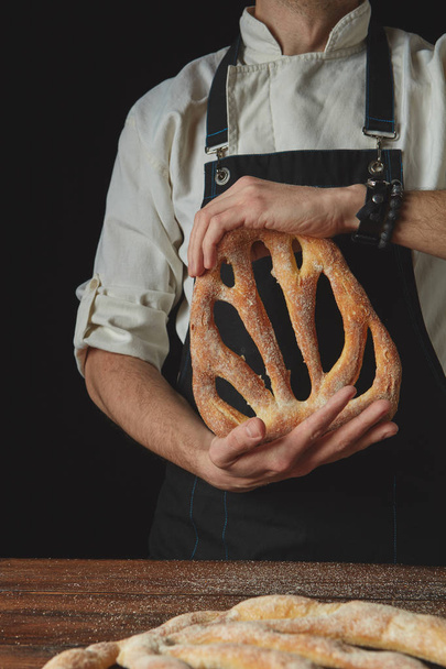 Baker holding fougas bread - Фото, изображение