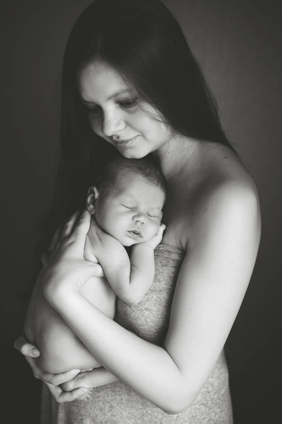  mother holding  sleeping newborn son - 写真・画像
