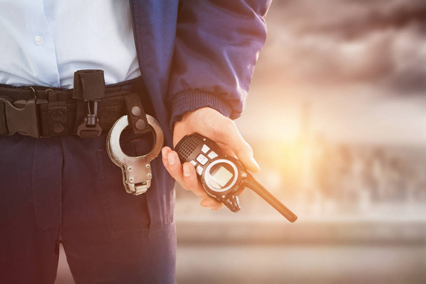 mid section of security officer holding walkie talkie - Foto, Imagem
