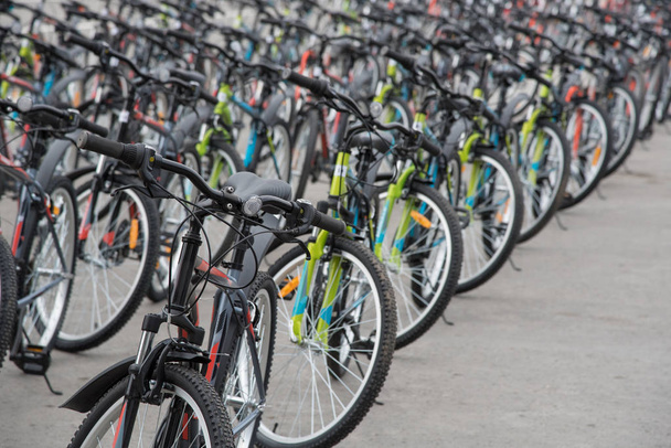 A row of a large number of bicycles with wheels on the town squa - Photo, Image